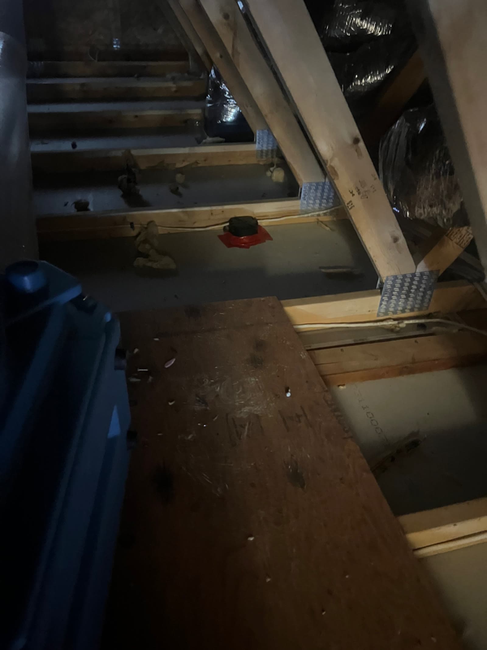 Attic joists with insulation removed and debris across the deck in a Bethel, CT home, before