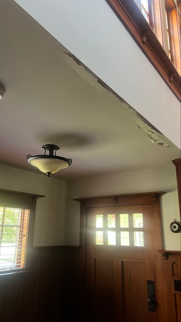 Water staining spreading across the foyer ceiling beside the front door of a Stamford, CT home