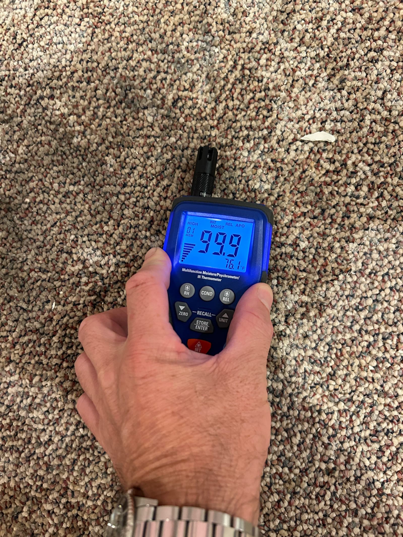 Moisture meter placed on wet carpet during a water damage assessment in a Trumbull, CT home