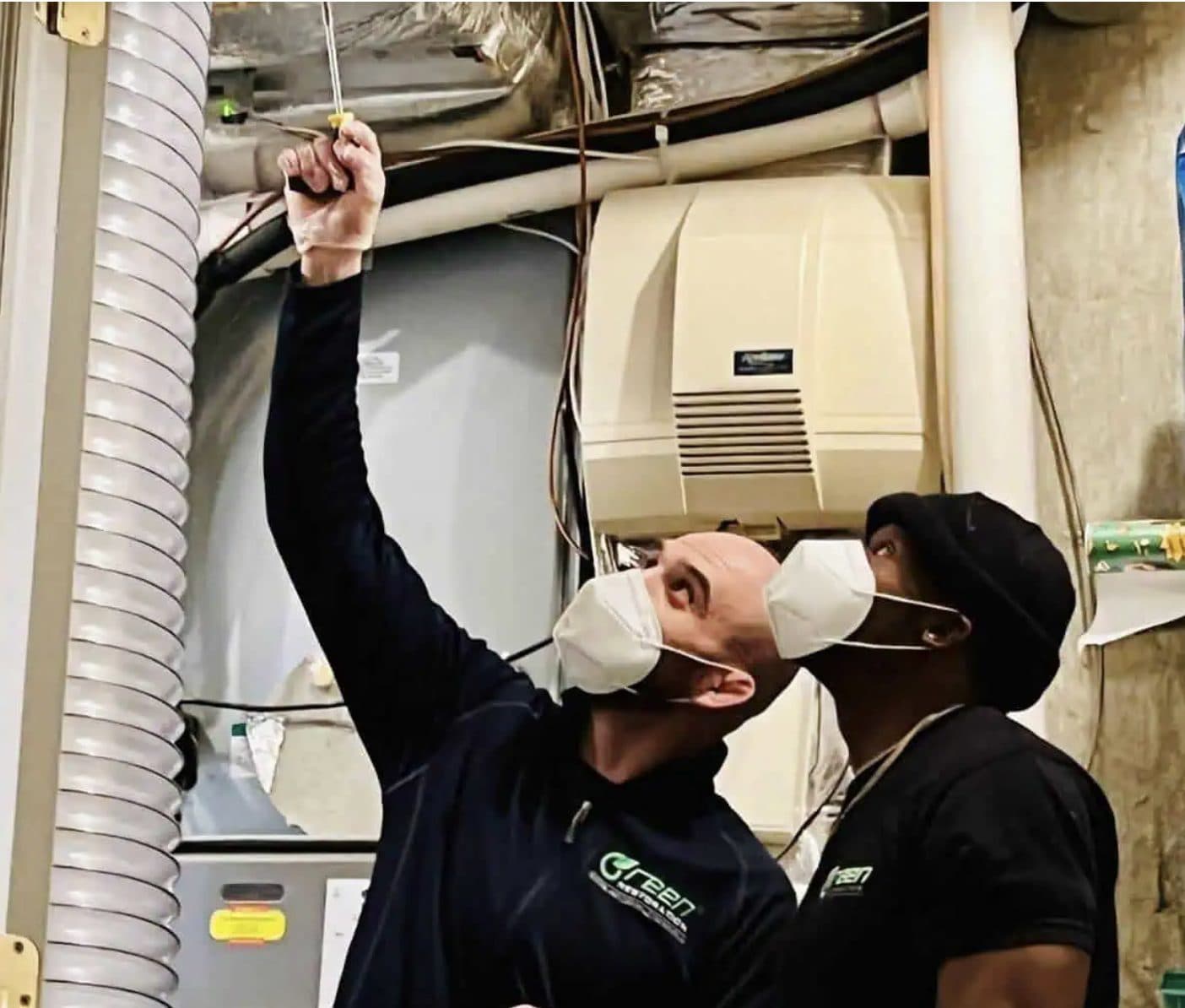Green Restoration technicians servicing an HVAC furnace plenum during NADCA-standard air duct cleaning
