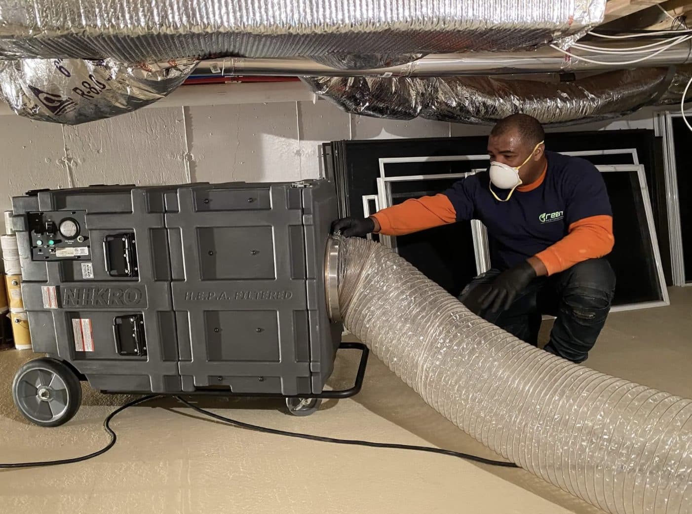 Negative-air HEPA capture and rotary brush kit staged at a residential dryer connection point during dryer vent cleaning in the tri-state