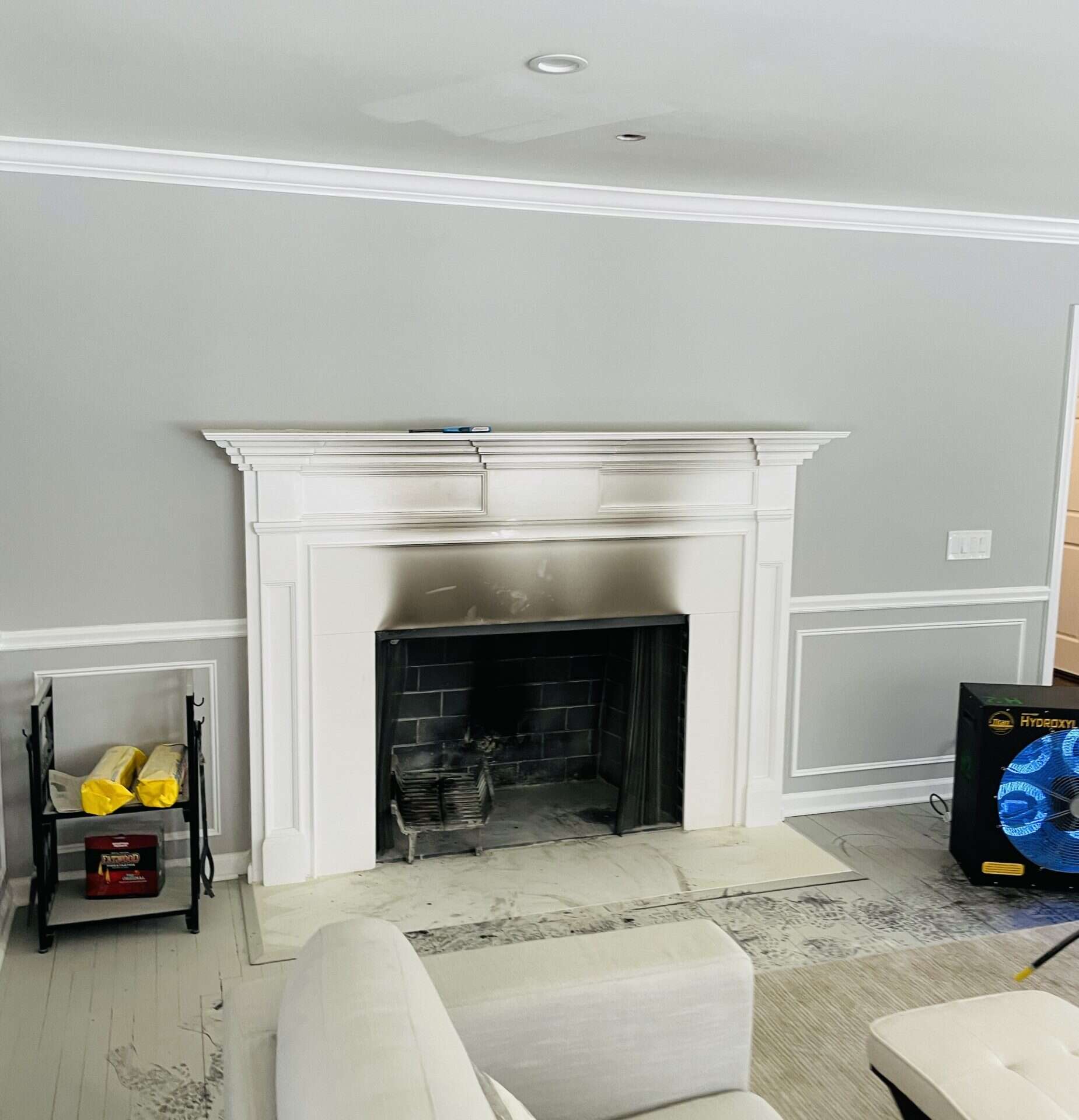 Soot staining above a fireplace surround with a hydroxyl generator running during smoke and soot cleanup by Green Restoration