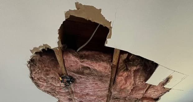Collapsed bedroom ceiling with saturated insulation hanging through broken drywall after a hidden leak in an Andover Connecticut area home, documented by Green Restoration